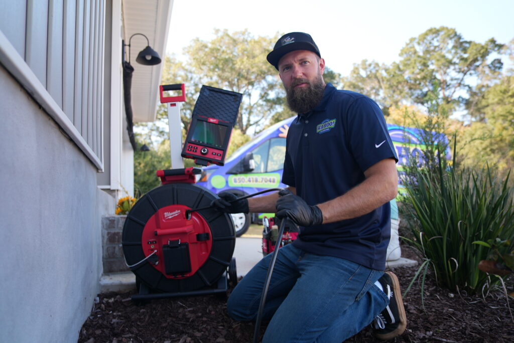 Professional plumber performing a camera sewer inspection using advanced diagnostic equipment.